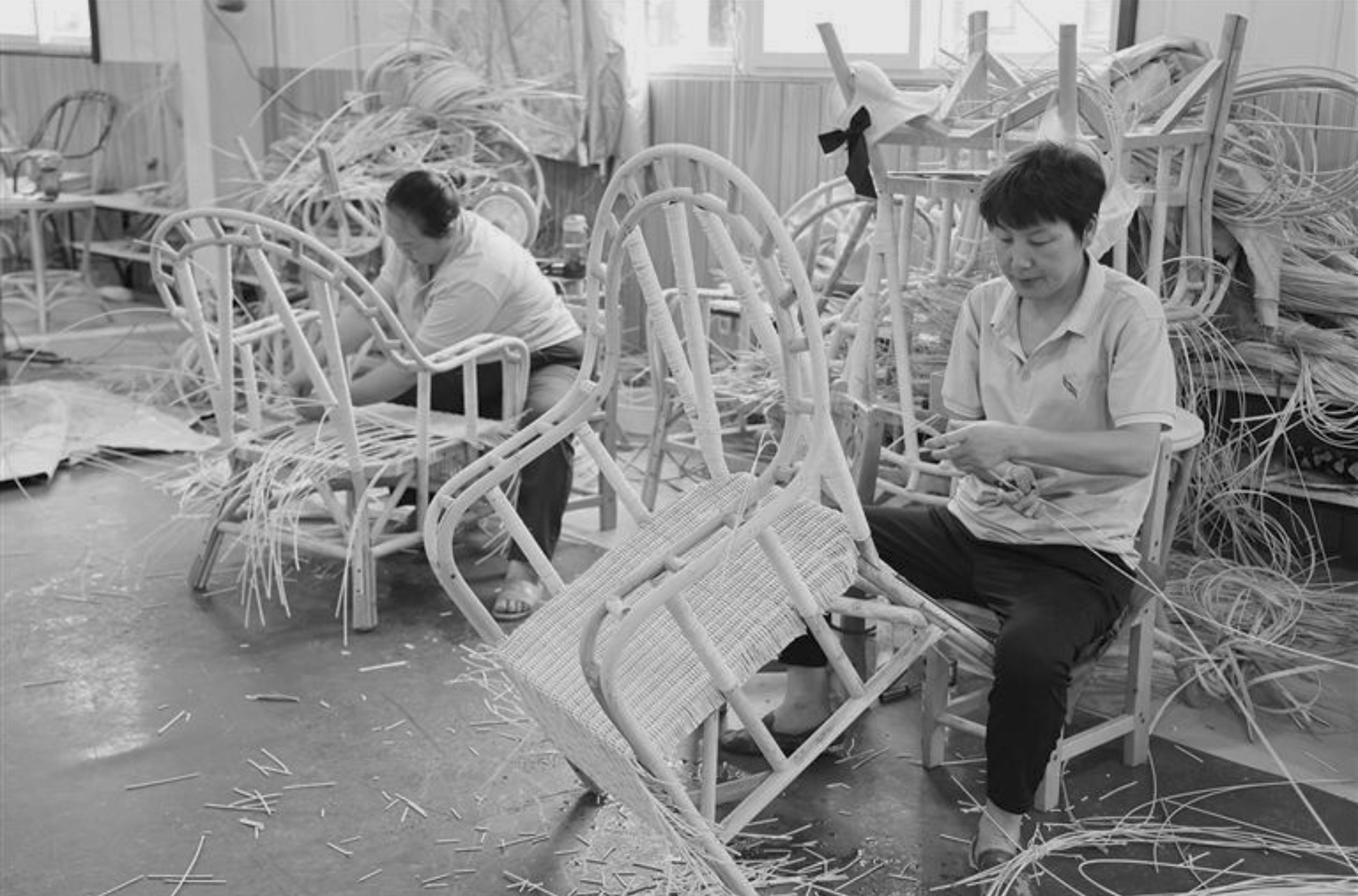 An artisan from a rattan furniture supplier skillfully weaving a piece of wicker furniture wholesale.